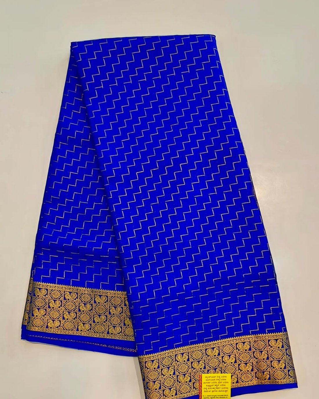 Royal blue pure Mysore silk crape saree with zigzag zari lines and gold peacock border